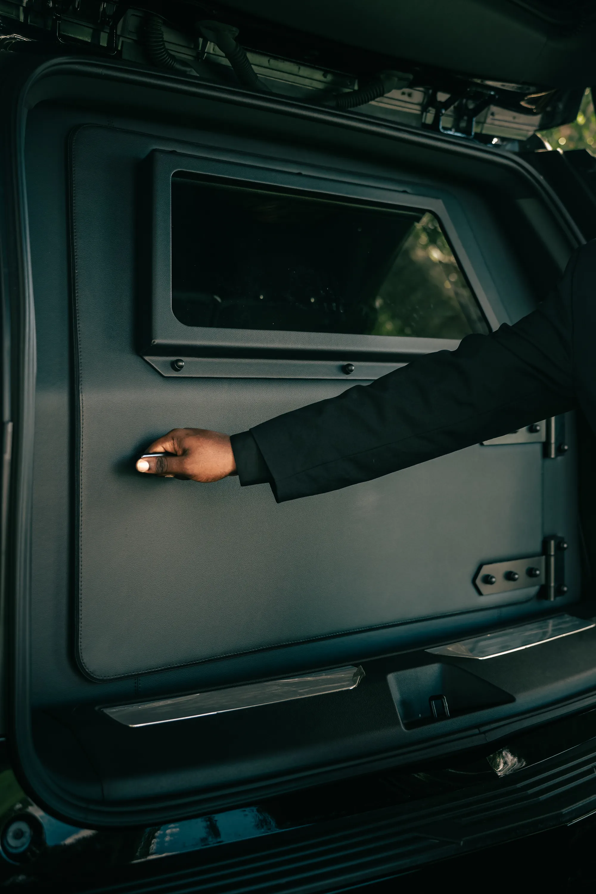 Armored partition behind the rear seats of the Prestige Guard Escalade, with a window in the panel